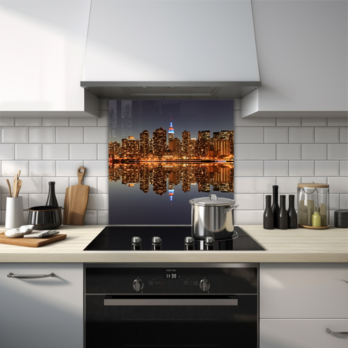 Night view of Manhattan's skyline reflected on water.