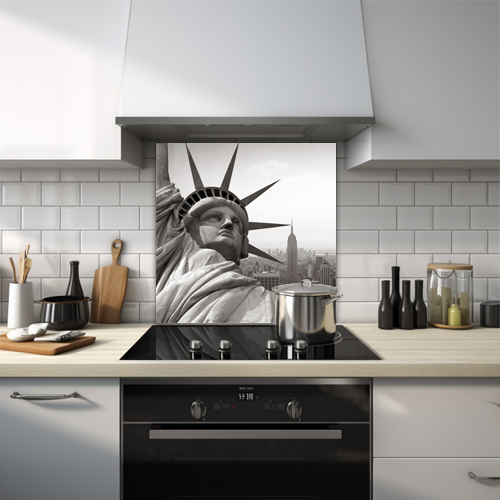 Black and white close-up of the Statue of Liberty with NYC skyline.