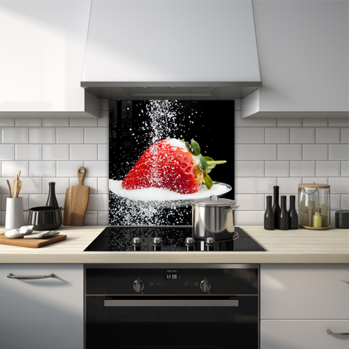 Close-up of a strawberry on a spoon with sugar being poured.
