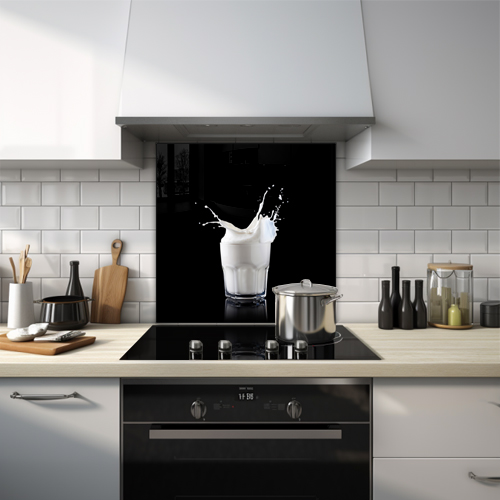 Glass of milk with milk splashing out on a black background.