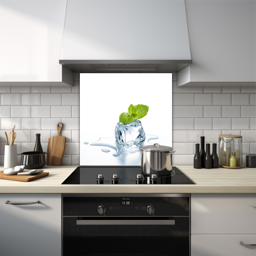 Splashback of an ice cube with a green mint, melting on a white background.