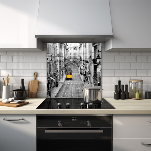 Black and white glass splashback with a colourful yellow tram in a city.