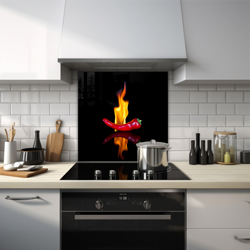 Glass splashback with a flaming chili and its reflection on a black background.