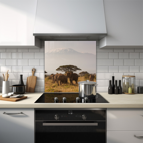 Elephants on African plain with tree and mountain backdrop glass splashback.