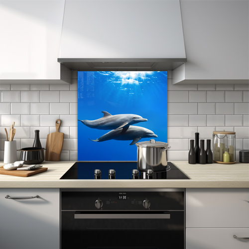 Two dolphins swimming together in the clear blue ocean glass splashback.