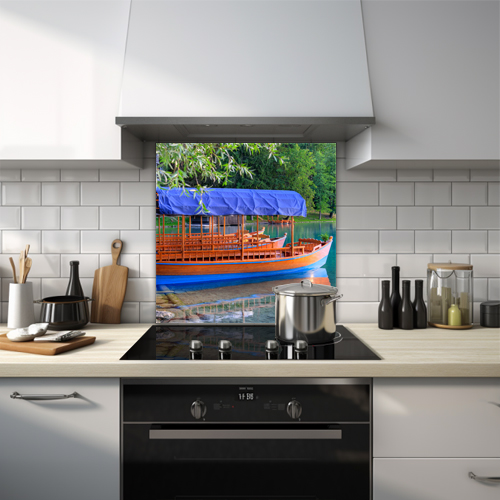 Glass splashback of a wooden boat with blue canopy on a serene lake.
