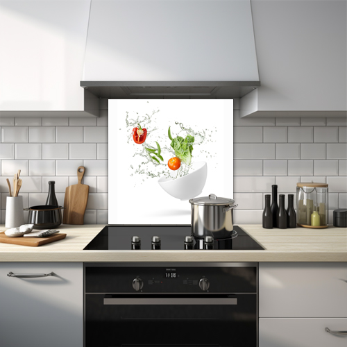 Vegetables splashing out of a bowl with water glass splashback.
