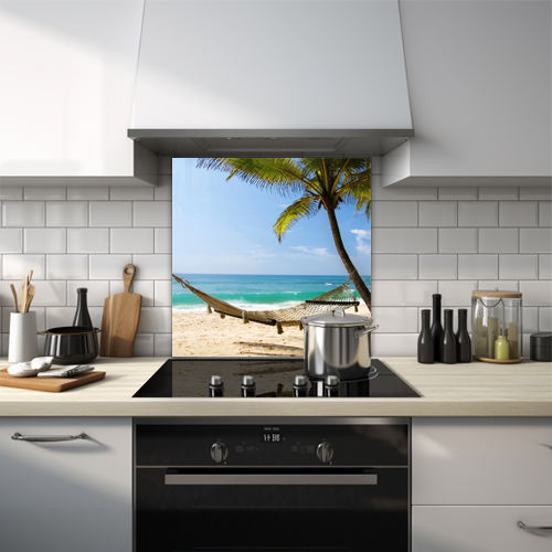 Hammock attached to a palm tree with ocean in the background on a tropical island glass splashback.