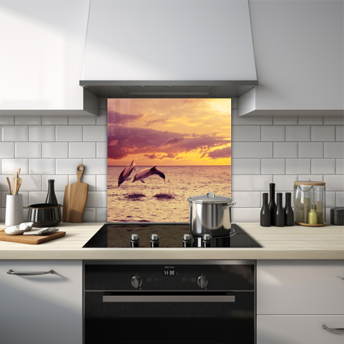 Glass splashback of two dolphins jumping out of the water during a sunset.