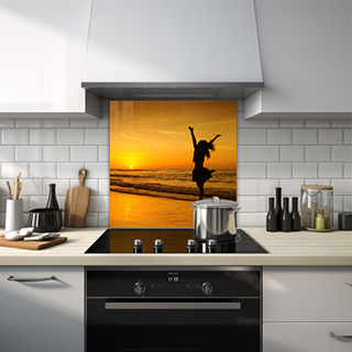 Lady jumping with joy on sunset beach glass splashback. thumbnail