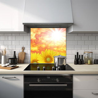 Sunflowers against orange cloudy sky and bright sun glass splashback. thumbnail